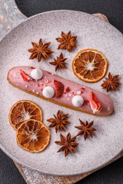 Koyu dokulu arka planda çilekli kremalı tatlı ekler veya profiterol.