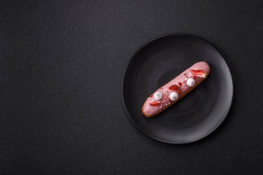 Koyu dokulu arka planda çilekli kremalı tatlı ekler veya profiterol.