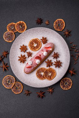 Koyu dokulu arka planda çilekli kremalı tatlı ekler veya profiterol.