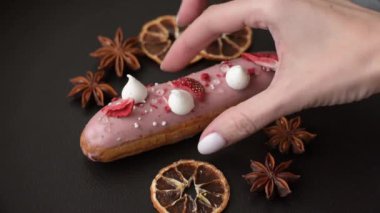 Koyu dokulu arka planda çilekli kremalı tatlı ekler veya profiterol.