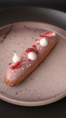 Koyu dokulu arka planda çilekli kremalı tatlı ekler veya profiterol.