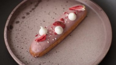 Koyu dokulu arka planda çilekli kremalı tatlı ekler veya profiterol.