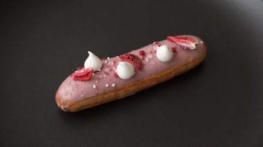 Koyu dokulu arka planda çilekli kremalı tatlı ekler veya profiterol.