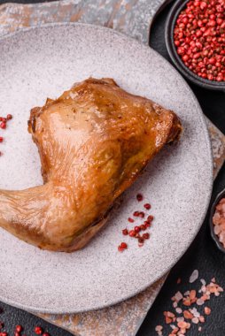 Lezzetli ızgara tavuk budu ya da koyu beton arka planda tuz ve baharatlı çeyreklik.