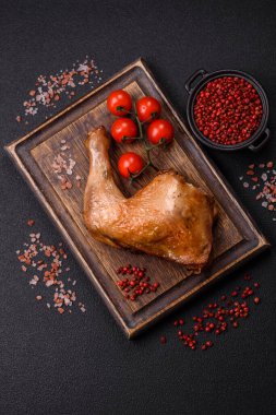 Lezzetli ızgara tavuk budu ya da koyu beton arka planda tuz ve baharatlı çeyreklik.