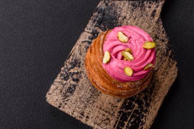 Tatlı yengeç ya da ahududu ve şam fıstığı aromalı kremayla süslenmiş koyu beton bir arka plan.