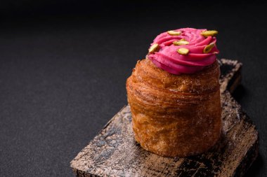 Tatlı yengeç ya da ahududu ve şam fıstığı aromalı kremayla süslenmiş koyu beton bir arka plan.