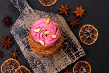 Tatlı yengeç ya da ahududu ve şam fıstığı aromalı kremayla süslenmiş koyu beton bir arka plan.