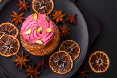 Tatlı yengeç ya da ahududu ve şam fıstığı aromalı kremayla süslenmiş koyu beton bir arka plan.