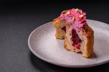 Tatlı yengeç ya da ahududu ve şam fıstığı aromalı kremayla süslenmiş koyu beton bir arka plan.