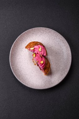 Tatlı yengeç ya da ahududu ve şam fıstığı aromalı kremayla süslenmiş koyu beton bir arka plan.