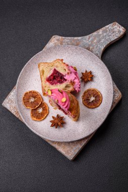 Tatlı yengeç ya da ahududu ve şam fıstığı aromalı kremayla süslenmiş koyu beton bir arka plan.