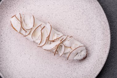 Koyu beton zeminde hindistan cevizi dilimleriyle süslenmiş muhallebi ekini.