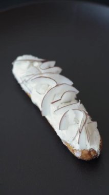 Koyu beton zeminde hindistan cevizi dilimleriyle süslenmiş muhallebi ekini.