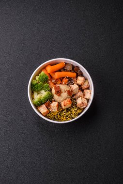 Renkli vejetaryen yemeği tofu, brokoli, kinoa, mantar ve havuçtan oluşur.