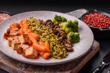 Renkli vejetaryen yemeği tofu, brokoli, kinoa, mantar ve havuçtan oluşur.