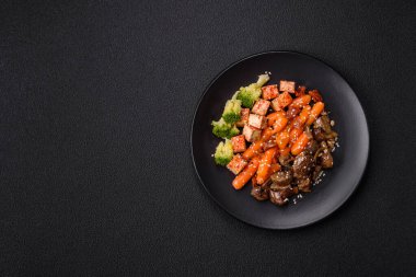 Renkli vejetaryen yemeği tofu, brokoli, kinoa, mantar ve havuçtan oluşur.