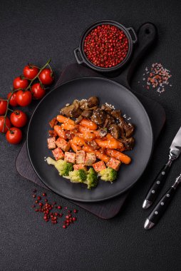 Renkli vejetaryen yemeği tofu, brokoli, kinoa, mantar ve havuçtan oluşur.