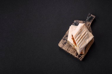 Pide, et, domates, peynir, sos, tuz ve baharatla birlikte koyu bir arkaplanda yuvarlan