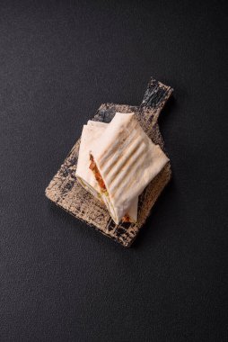 Pide, et, domates, peynir, sos, tuz ve baharatla birlikte koyu bir arkaplanda yuvarlan