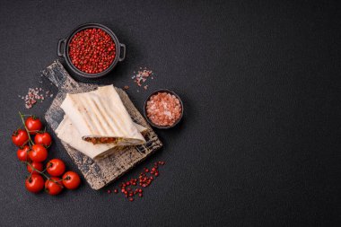 Pide, et, domates, peynir, sos, tuz ve baharatla birlikte koyu bir arkaplanda yuvarlan