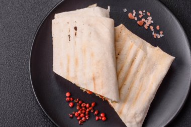 Pide, et, domates, peynir, sos, tuz ve baharatla birlikte koyu bir arkaplanda yuvarlan