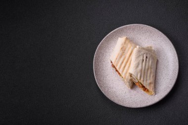 Pide, et, domates, peynir, sos, tuz ve baharatla birlikte koyu bir arkaplanda yuvarlan