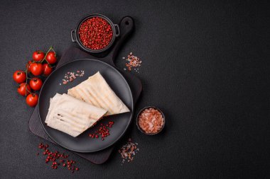 Pide, et, domates, peynir, sos, tuz ve baharatla birlikte koyu bir arkaplanda yuvarlan