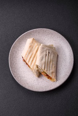 Pide, et, domates, peynir, sos, tuz ve baharatla birlikte koyu bir arkaplanda yuvarlan