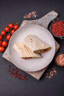 Pide, et, domates, peynir, sos, tuz ve baharatla birlikte koyu bir arkaplanda yuvarlan