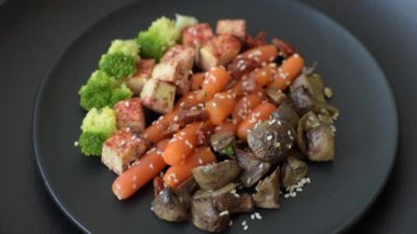 Renkli vejetaryen yemeği tofu, brokoli, kinoa, mantar ve havuçtan oluşur.