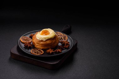 Kuru üzümlü, kremalı ve armutlu tatlı Danimarka ekmeği koyu beton bir arka planda.