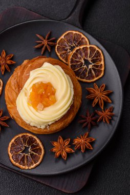 Kuru üzümlü, kremalı ve armutlu tatlı Danimarka ekmeği koyu beton bir arka planda.