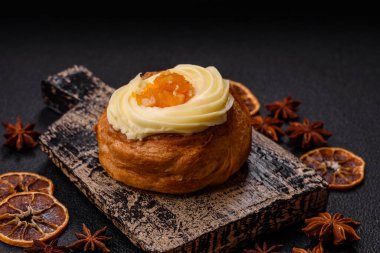 Kuru üzümlü, kremalı ve armutlu tatlı Danimarka ekmeği koyu beton bir arka planda.