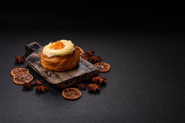 Kuru üzümlü, kremalı ve armutlu tatlı Danimarka ekmeği koyu beton bir arka planda.