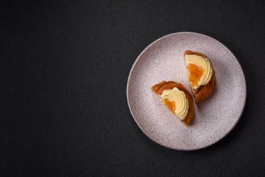 Kuru üzümlü, kremalı ve armutlu tatlı Danimarka ekmeği koyu beton bir arka planda.