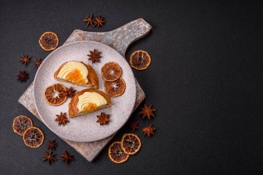 Kuru üzümlü, kremalı ve armutlu tatlı Danimarka ekmeği koyu beton bir arka planda.