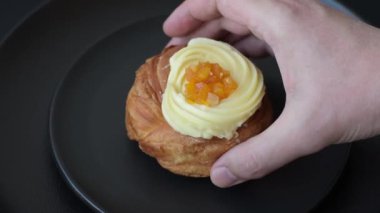 Kuru üzümlü, kremalı ve armutlu tatlı Danimarka ekmeği koyu beton bir arka planda.