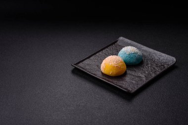 Lezzetli Asya mochi tatlısı pirinç hamuru kabuğu ve koyu beton arka planda meyveler.