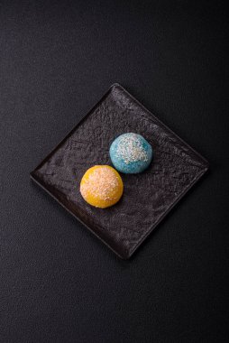 Lezzetli Asya mochi tatlısı pirinç hamuru kabuğu ve koyu beton arka planda meyveler.