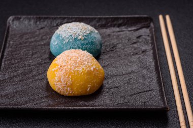 Lezzetli Asya mochi tatlısı pirinç hamuru kabuğu ve koyu beton arka planda meyveler.