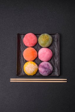 Lezzetli Asya mochi tatlısı pirinç hamuru kabuğu ve koyu beton arka planda meyveler.