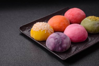 Lezzetli Asya mochi tatlısı pirinç hamuru kabuğu ve koyu beton arka planda meyveler.