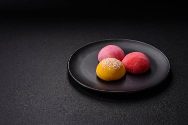Lezzetli Asya mochi tatlısı pirinç hamuru kabuğu ve koyu beton arka planda meyveler.
