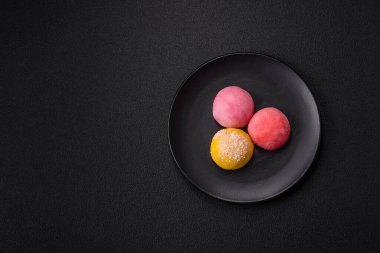 Lezzetli Asya mochi tatlısı pirinç hamuru kabuğu ve koyu beton arka planda meyveler.