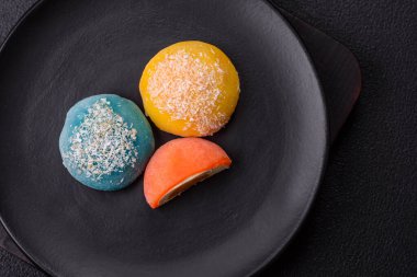 Lezzetli Asya mochi tatlısı pirinç hamuru kabuğu ve koyu beton arka planda meyveler.