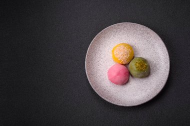 Lezzetli Asya mochi tatlısı pirinç hamuru kabuğu ve koyu beton arka planda meyveler.