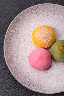 Lezzetli Asya mochi tatlısı pirinç hamuru kabuğu ve koyu beton arka planda meyveler.