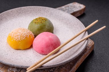Lezzetli Asya mochi tatlısı pirinç hamuru kabuğu ve koyu beton arka planda meyveler.