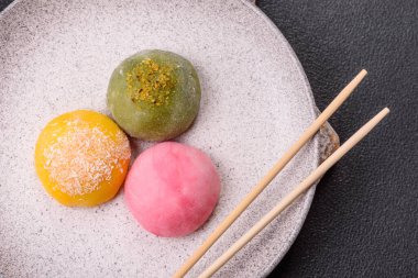 Lezzetli Asya mochi tatlısı pirinç hamuru kabuğu ve koyu beton arka planda meyveler.
